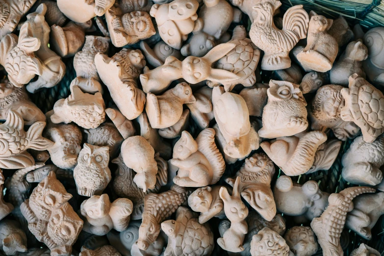 lots of carved clay head in a basket