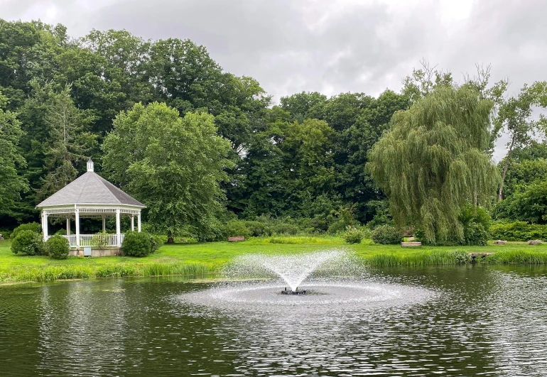 a white gazebo is in the middle of a lake