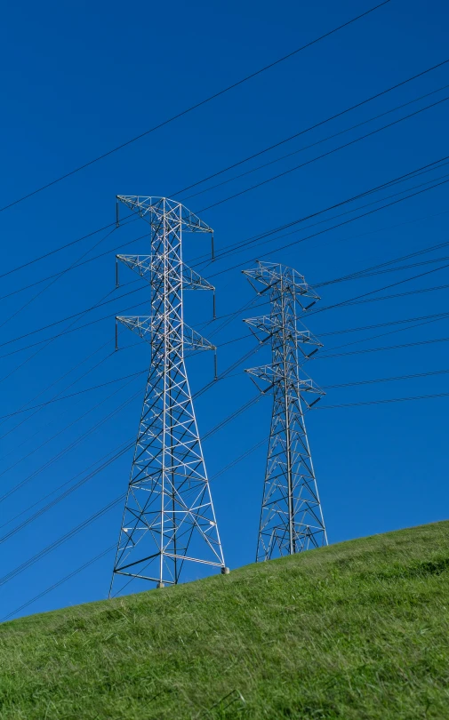 the power lines on the side of the hill are a beautiful example of green grass