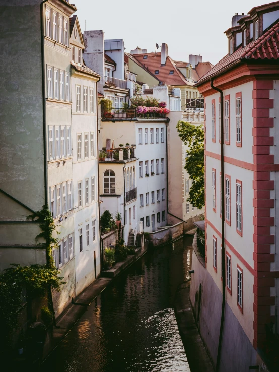 a river surrounded by buildings that are pink and white