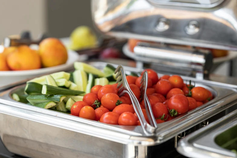 a serving dish with various fruits and vegetables in it