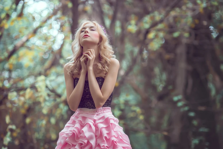 a woman wearing pink dresses and holding her hands together