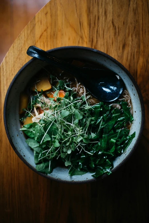 a bowl of food with some noodles and some veggies