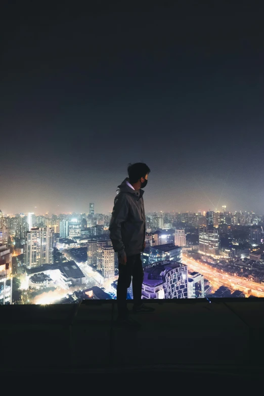 a man looking out over a city skyline at night