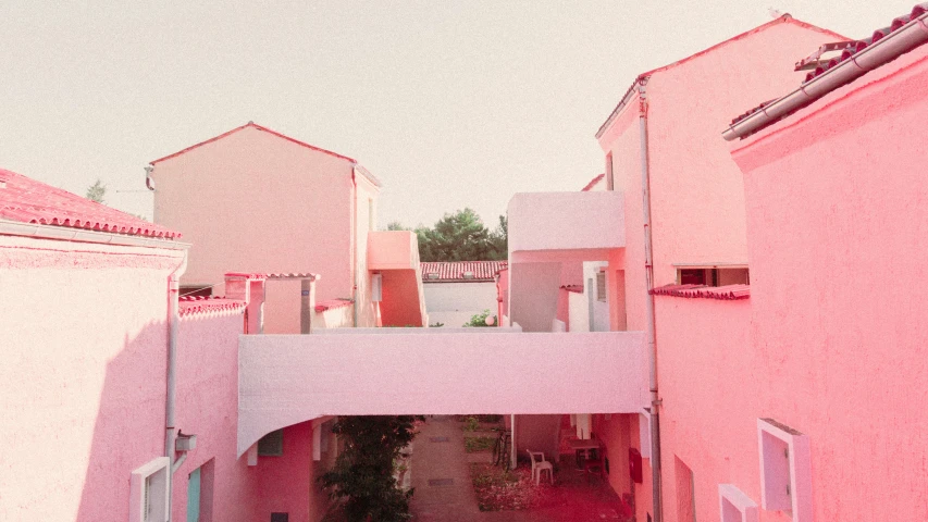 a pink street lined with white houses and buildings