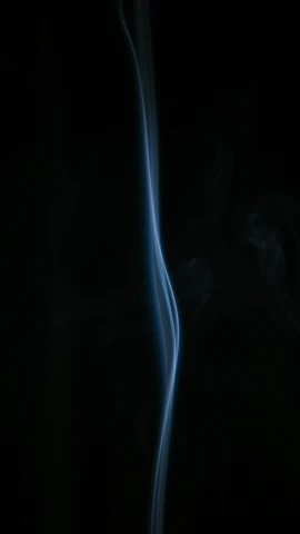 smoke rising in the dark on a black background