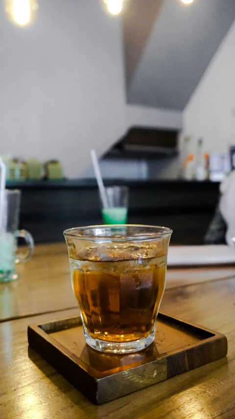 a glass of tea is on a wooden tray