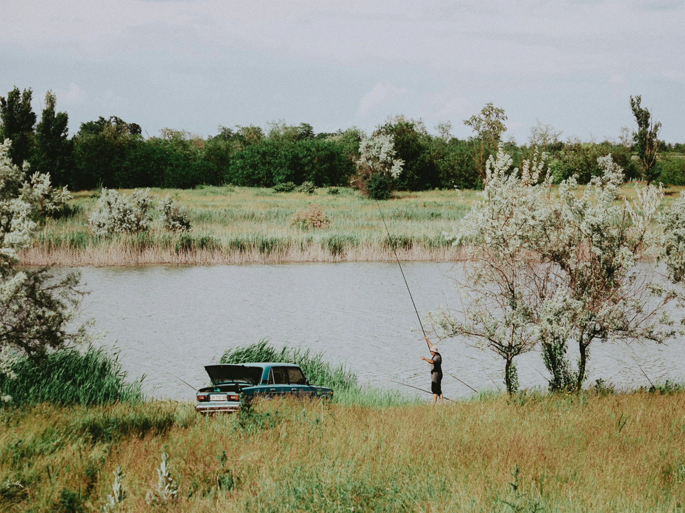 a fisherman casting a line for his boat on the river