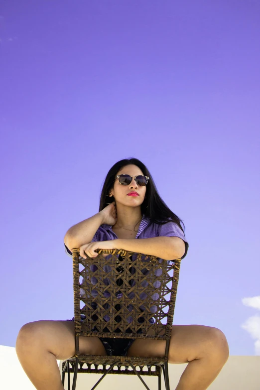 a woman in tight pants and glasses sitting on a chair