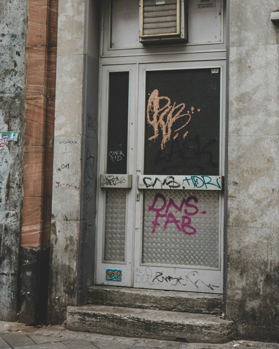 graffiti and writing are all over the windows of this old building