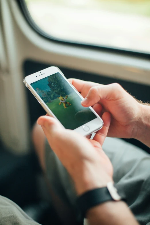 a person sitting on a train playing the nintendo wii game