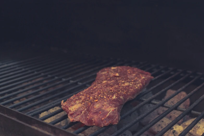 a piece of meat is on the grill cooking