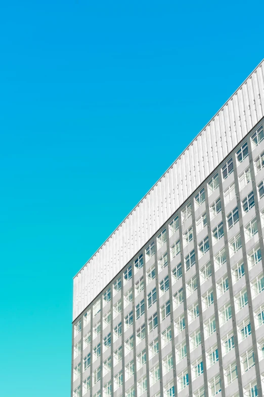 a tall building with multiple windows and blue sky