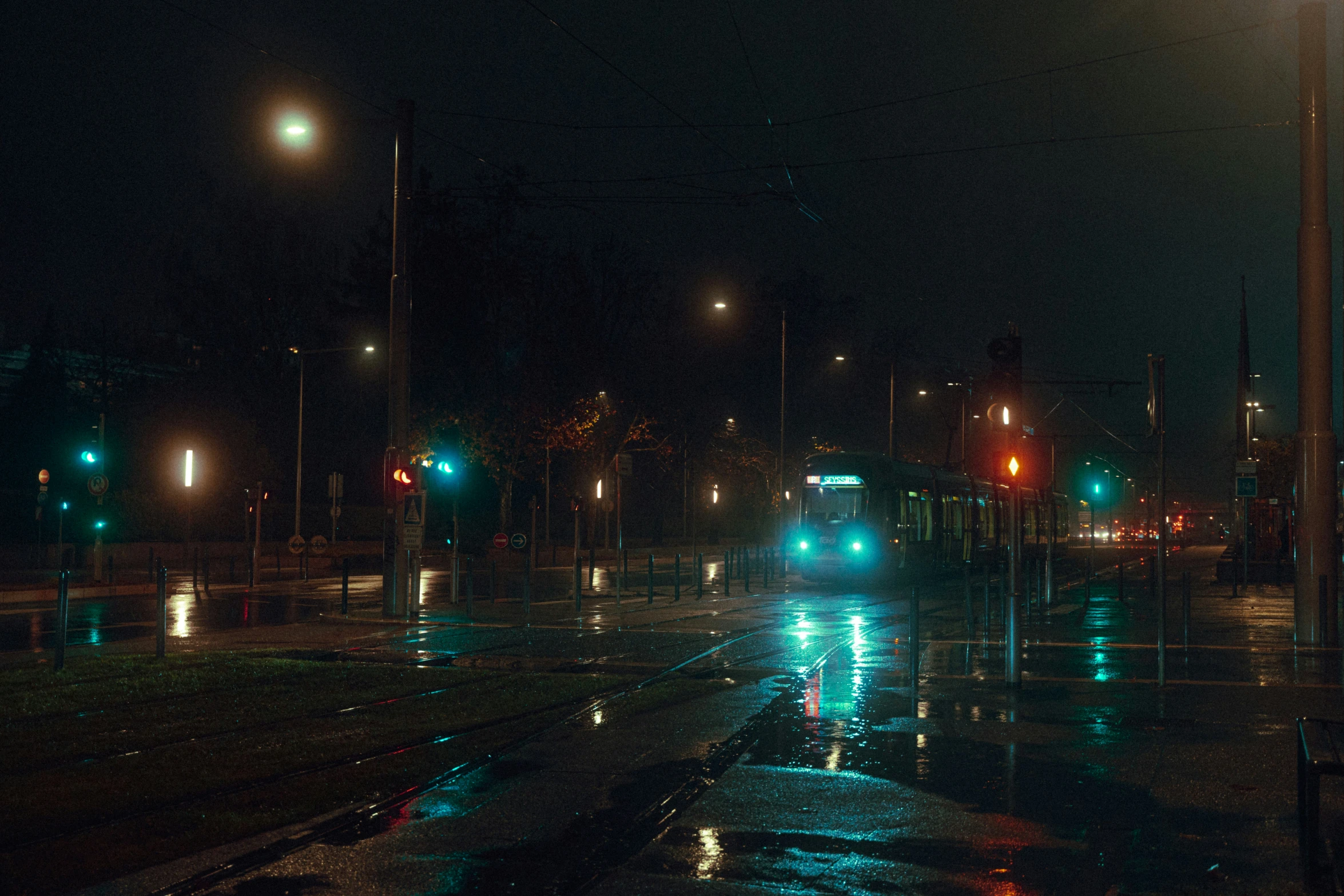 traffic light, street lights and busses at night on rainy night