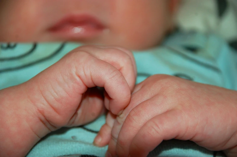 a baby holding his hand out in the air