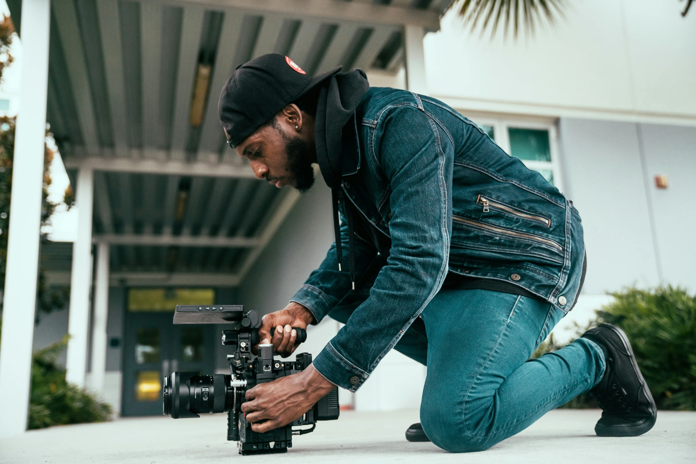 a man kneeling down next to a camera on the ground