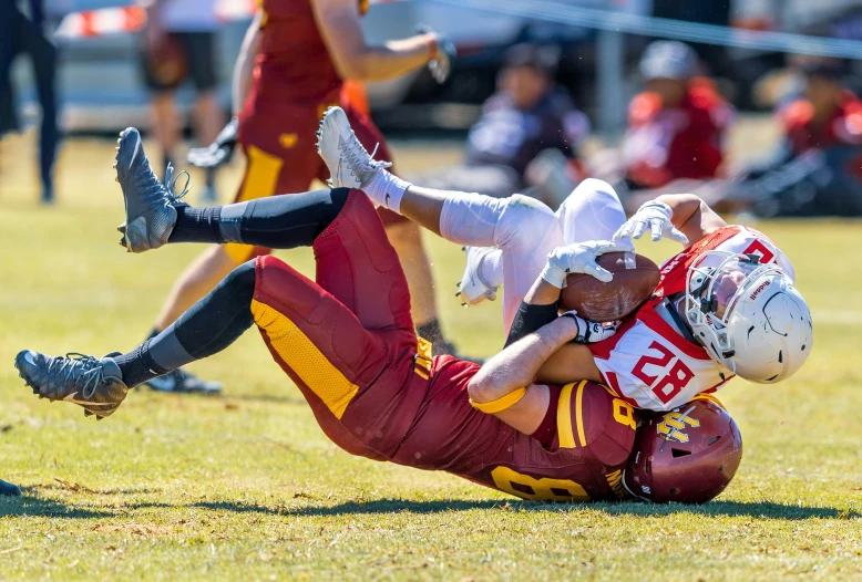 the football players are in a game, and one is lying on the ground