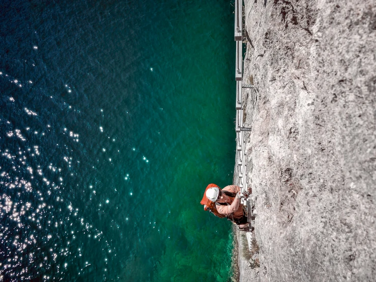 two people sitting on the beach with their hands over their hipss