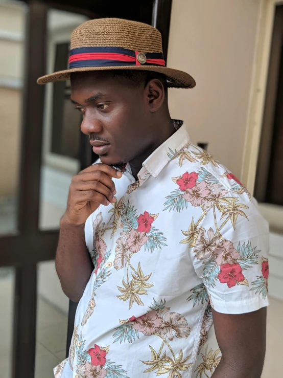 a young man is wearing a colorful shirt and fedora