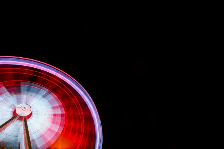 a ferris wheel spinning in a dark sky