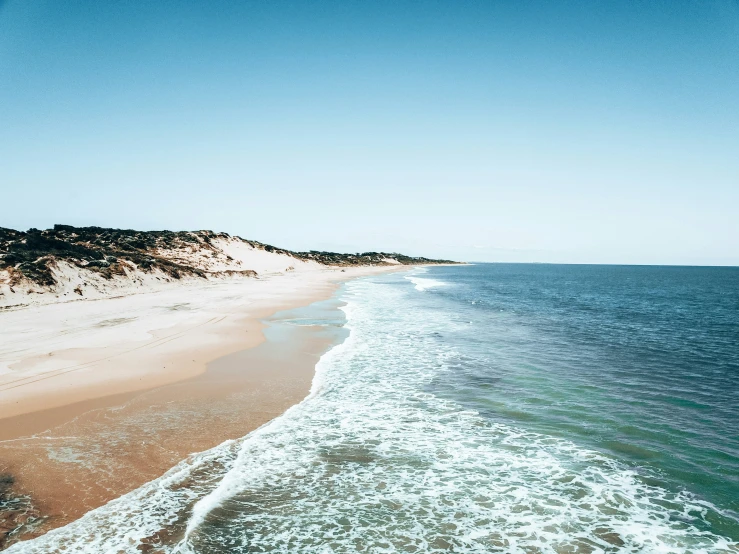 an aerial view of an ocean and beach near the ocean