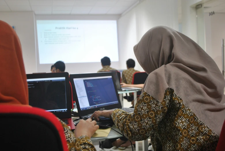 people using computers in a large class room