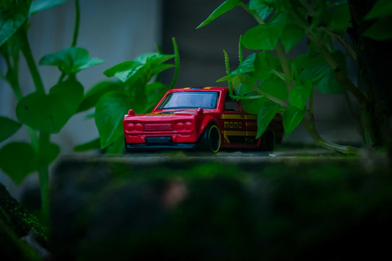 a toy truck is sitting in front of a bush