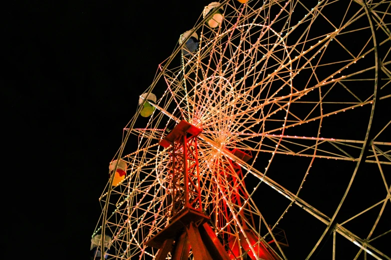 a large ferris wheel is shown with red lights on it