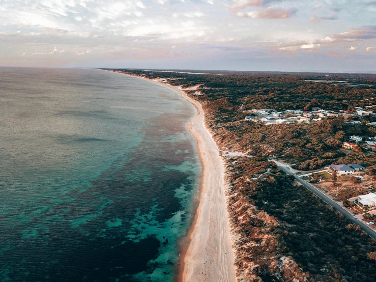 an aerial view of the ocean with houses and trees