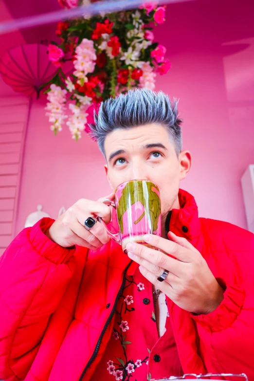 a woman with blue hair drinking coffee while wearing a bright red coat