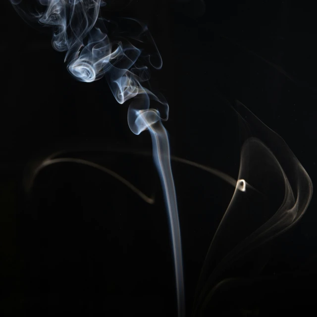 a black background with smoke from the ends