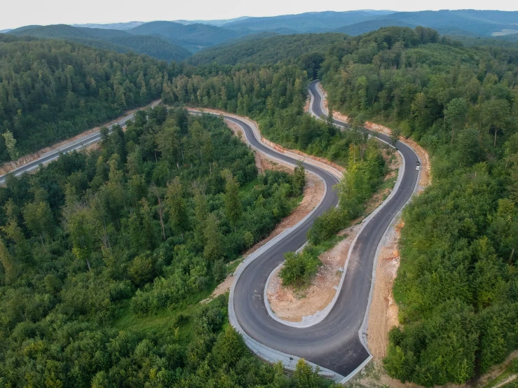 a winding road in a mountain with lots of trees