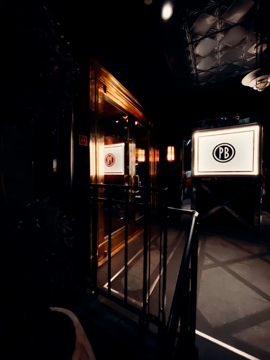 a dark hallway at the end of an indoor facility with signage on it