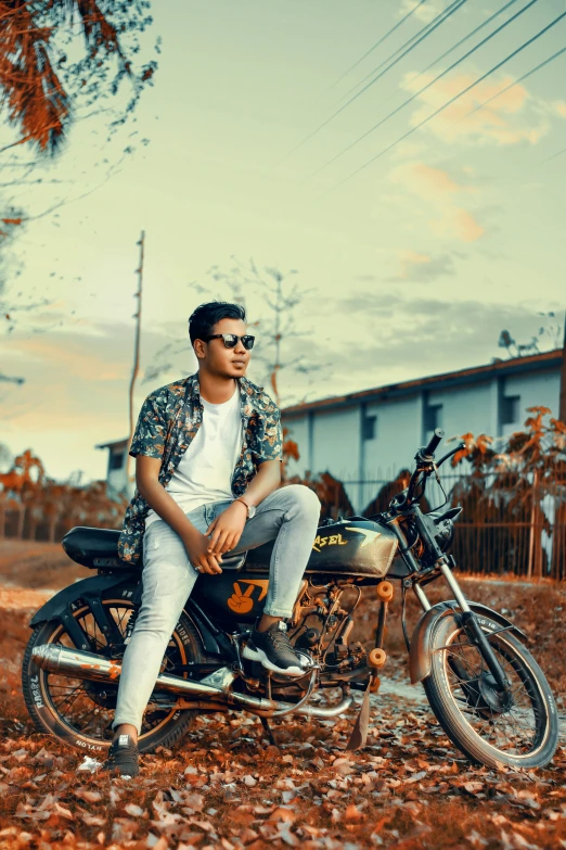 a young man sitting on top of a motor bike