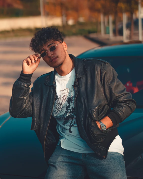 a person leaning on a car talking on a cell phone