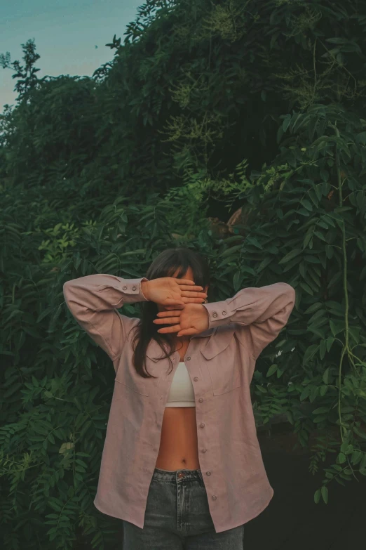 a woman holding her hands up to her face