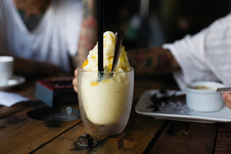 a person sitting down at a table with some food and drinks