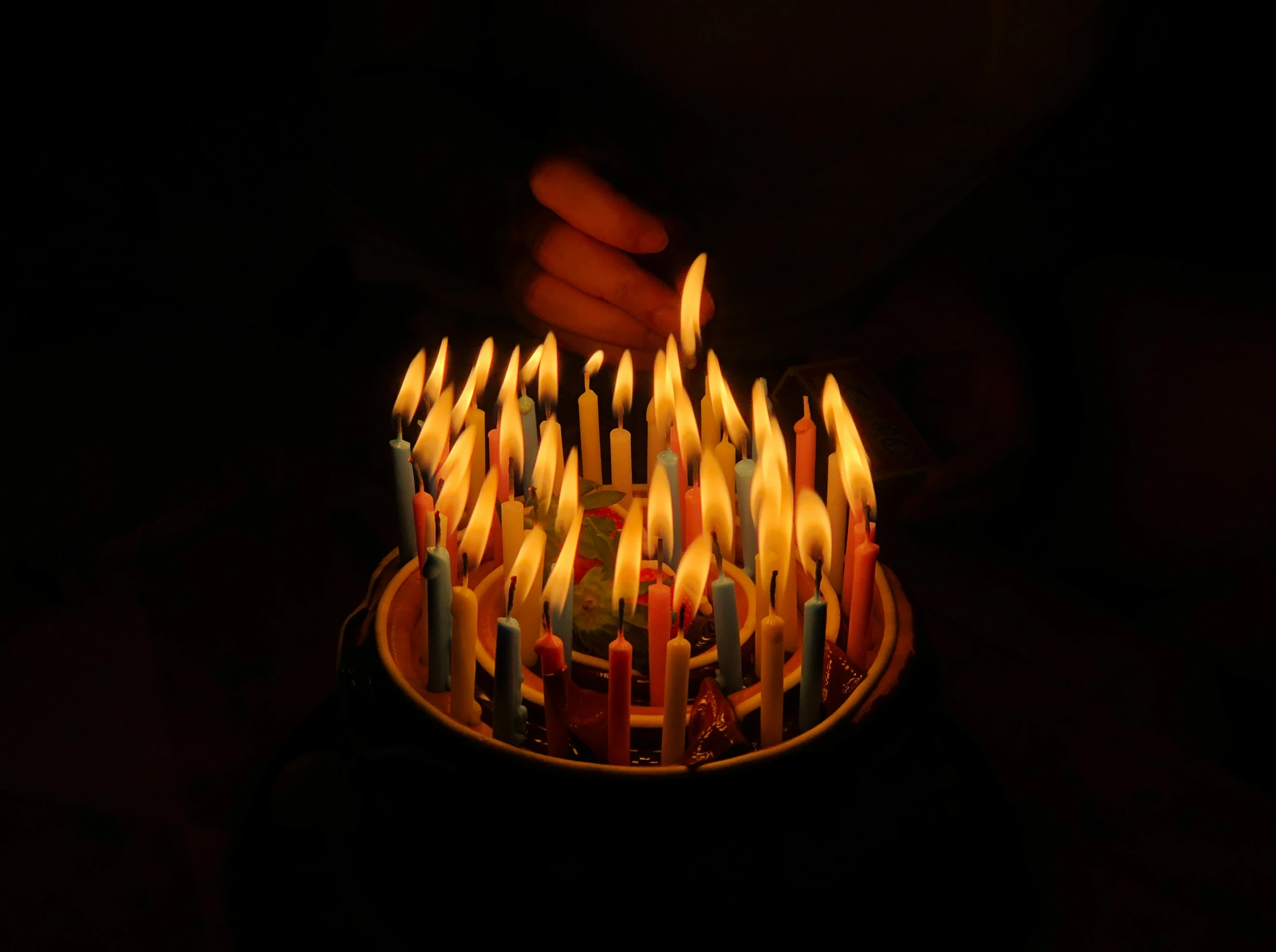 many lit candles in a bowl on a table