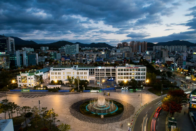 an overview of a city at night with a fountain