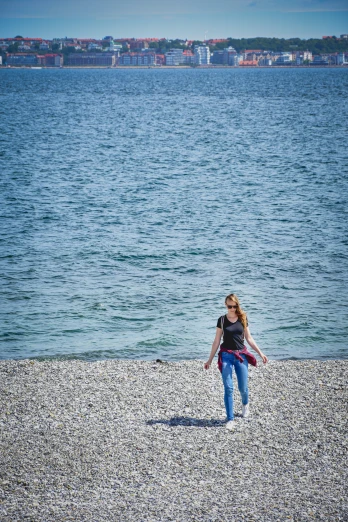 a woman walking on the shore near water