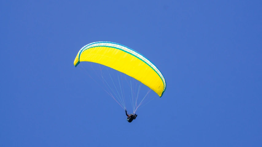 a parachute being carried through the air by a man riding it