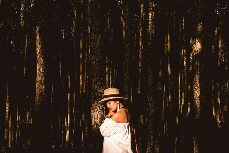 a woman standing in the woods talking on a cell phone