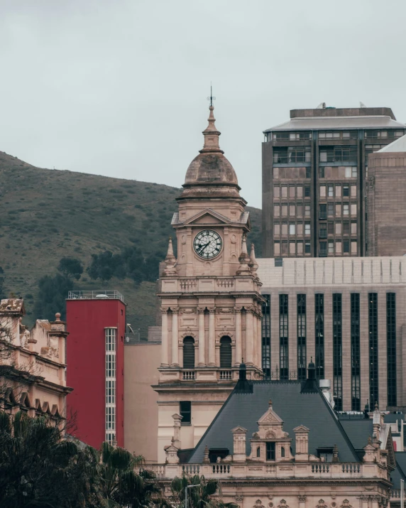 large buildings and a clock tower next to a mountain