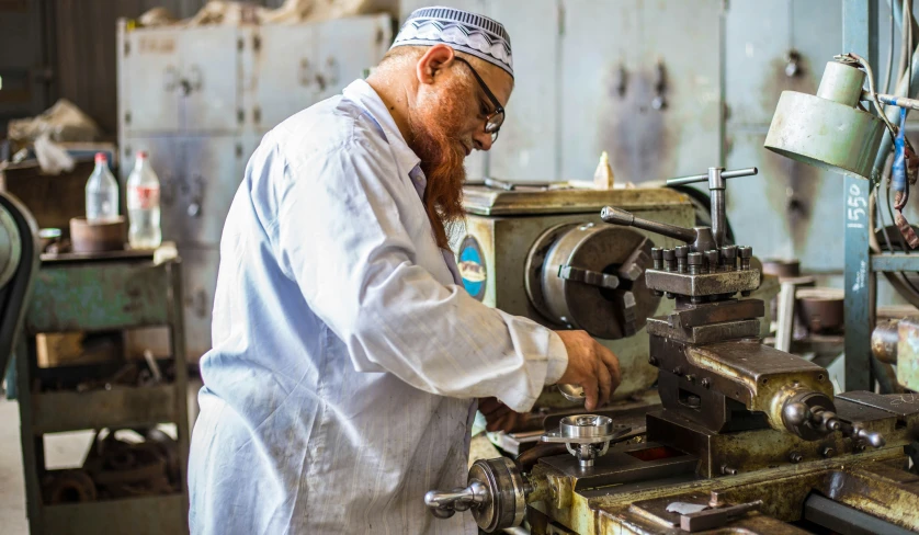 a man in a factory using an old machine