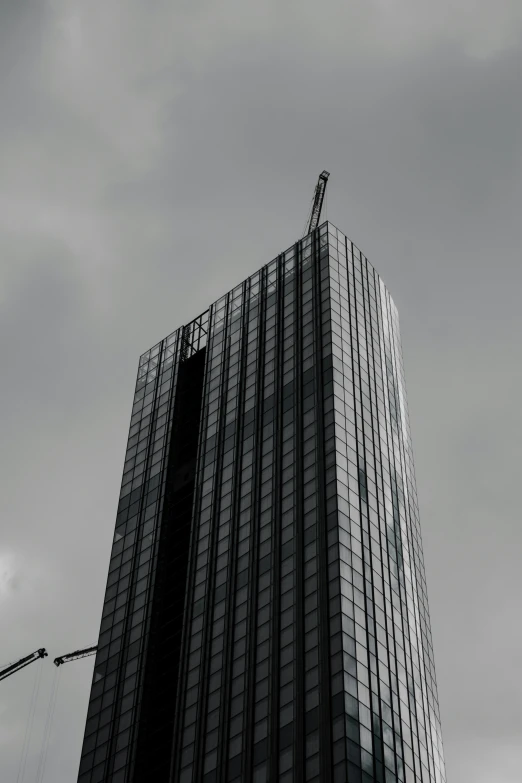 a tower with cranes in the background and a building being built