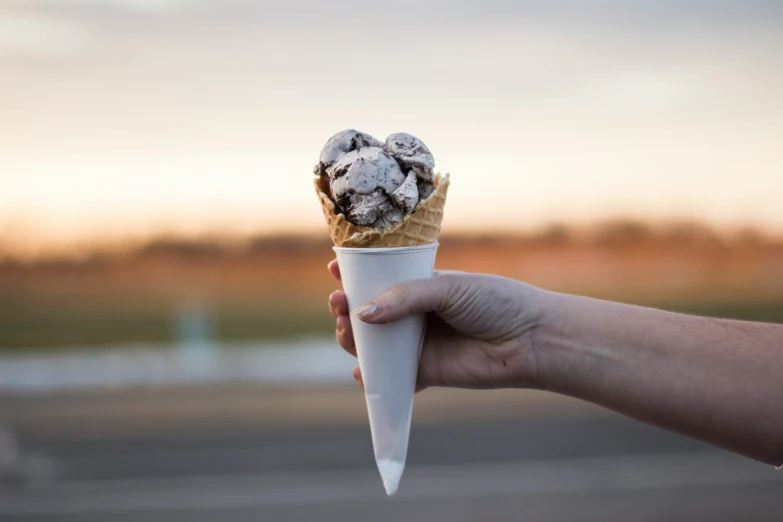 a hand holding a cone filled with cookies