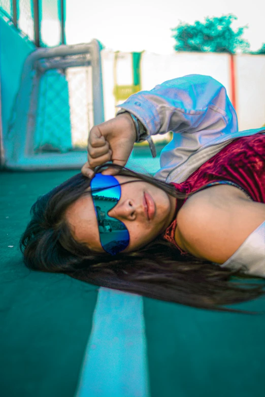a woman lying on the ground in sunglasses