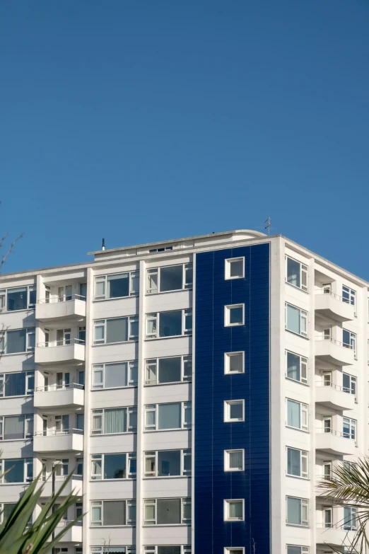 a tall white and blue building with a clock on the front