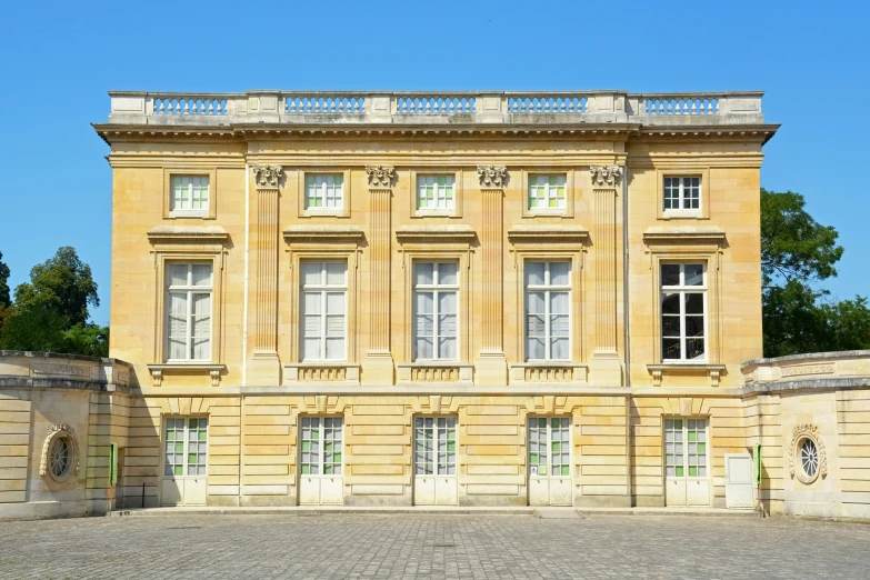 a very old building with white windows and a clock in front