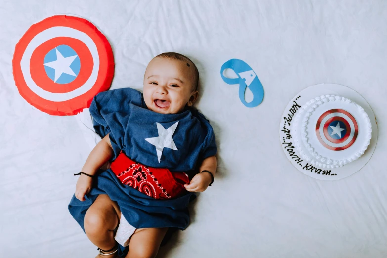 a baby lies on a bed near paper circles